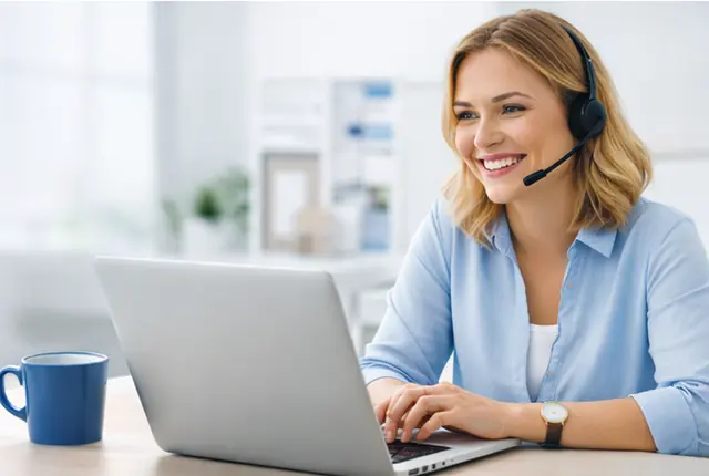 Support-Mitarbeiterin mit Headset arbeitet am Laptop